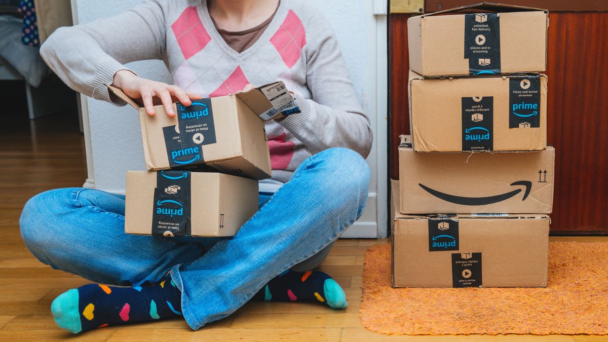 Woman sitting on floor opening boxes of online purchases