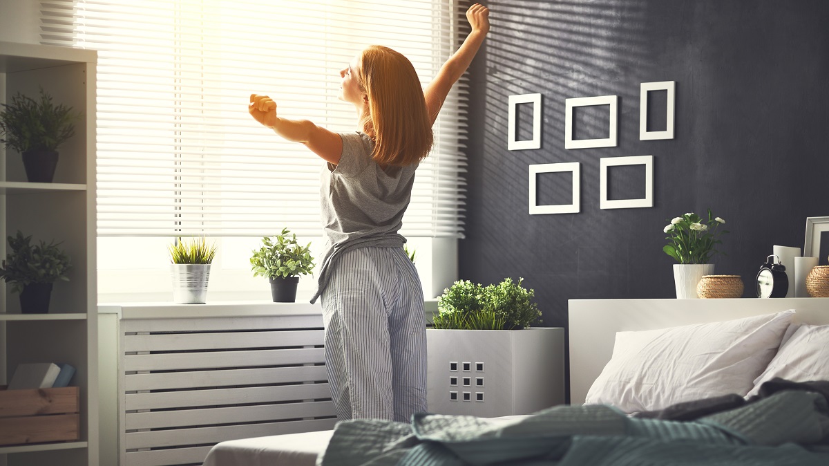 Woman stretching in morning next to bed