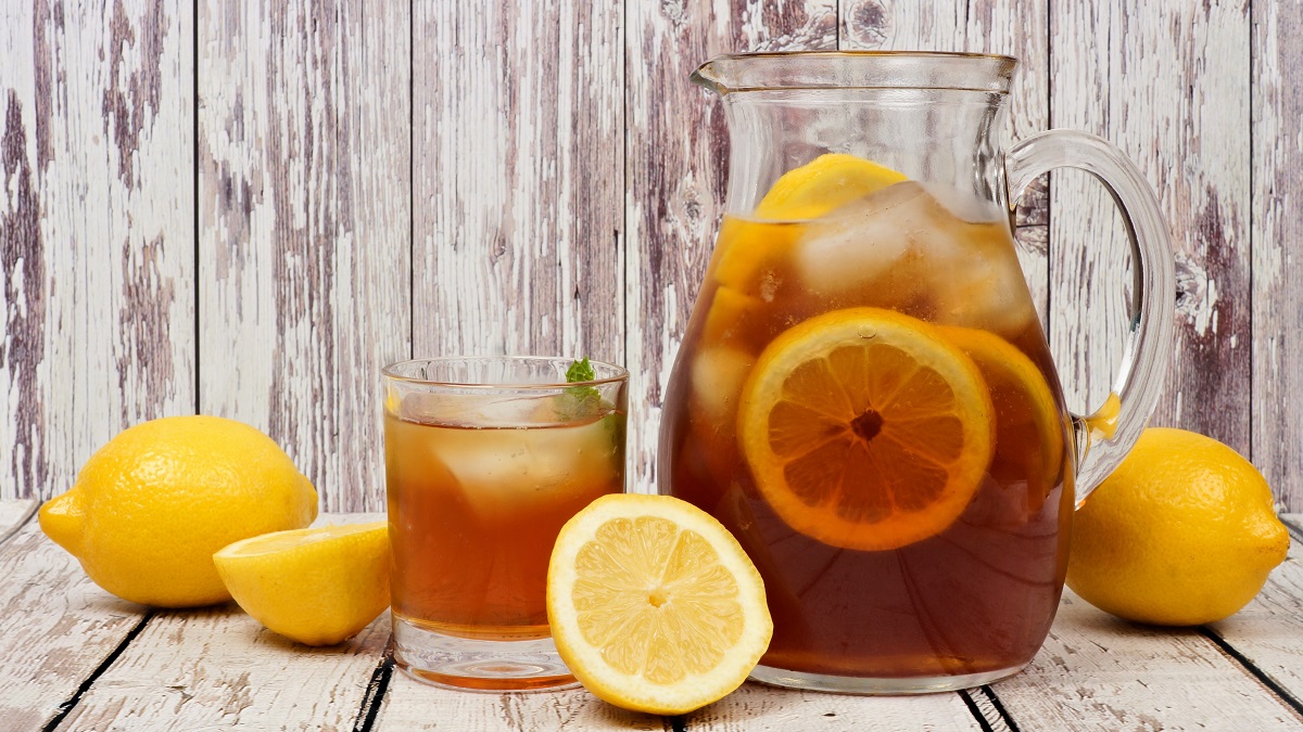 Pitcher of iced tea with a glass and lemons