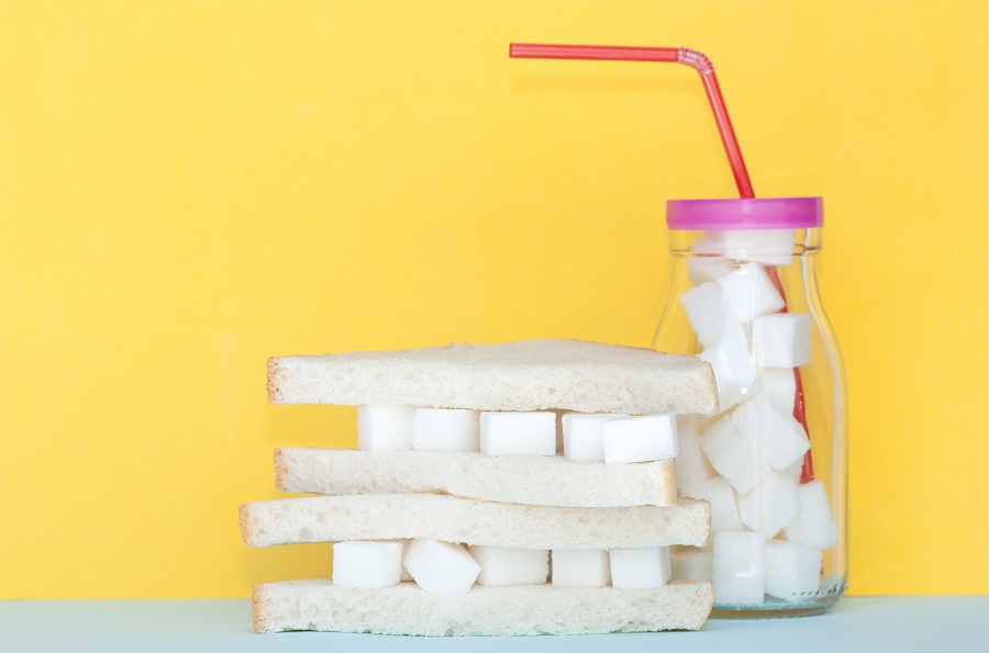 white bread sandwich of sugar cubes and a beverage bottle filled with sugar
