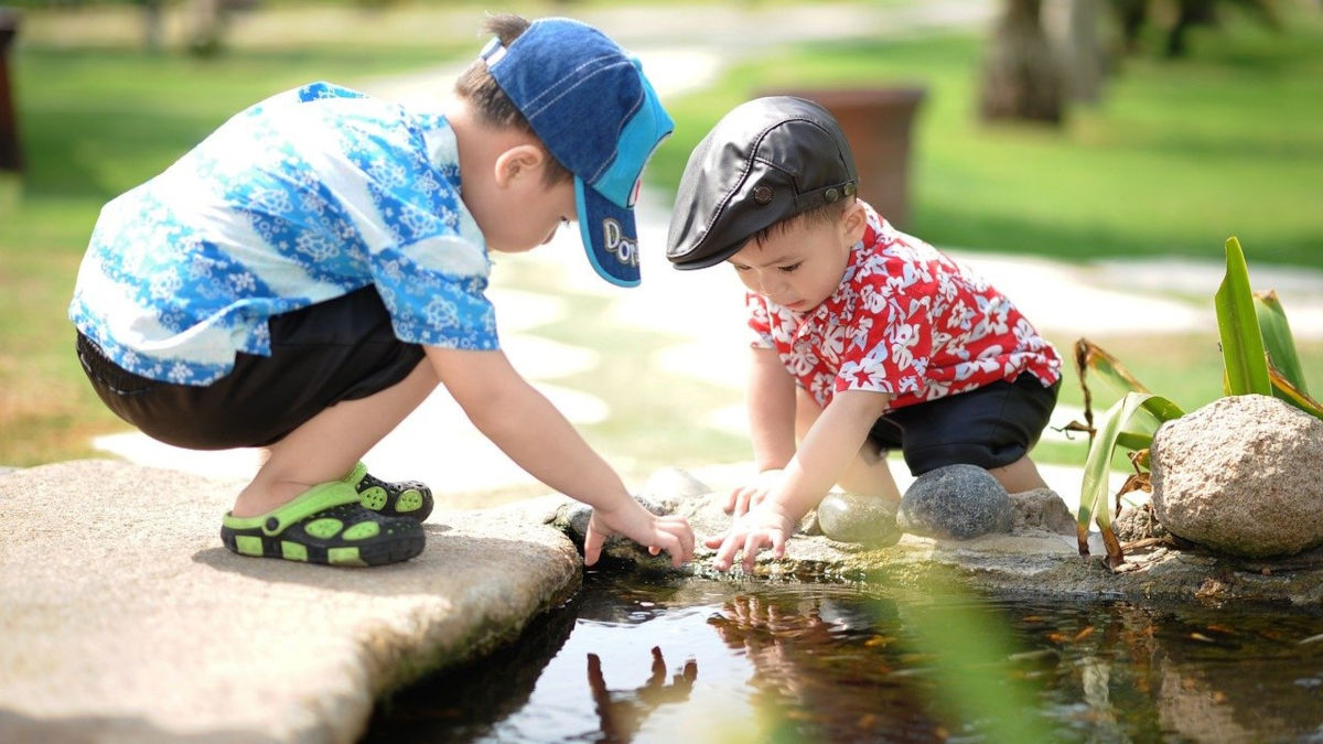 little boys playing with pond water
