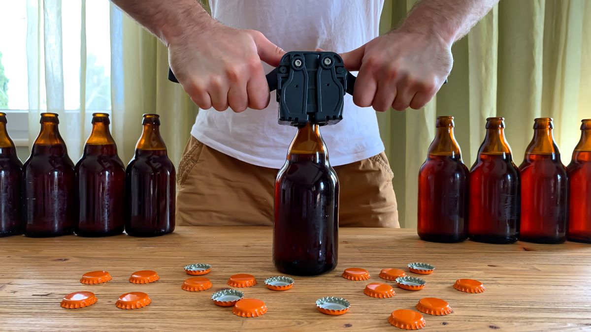 man capping bottles of homebrewed beer
