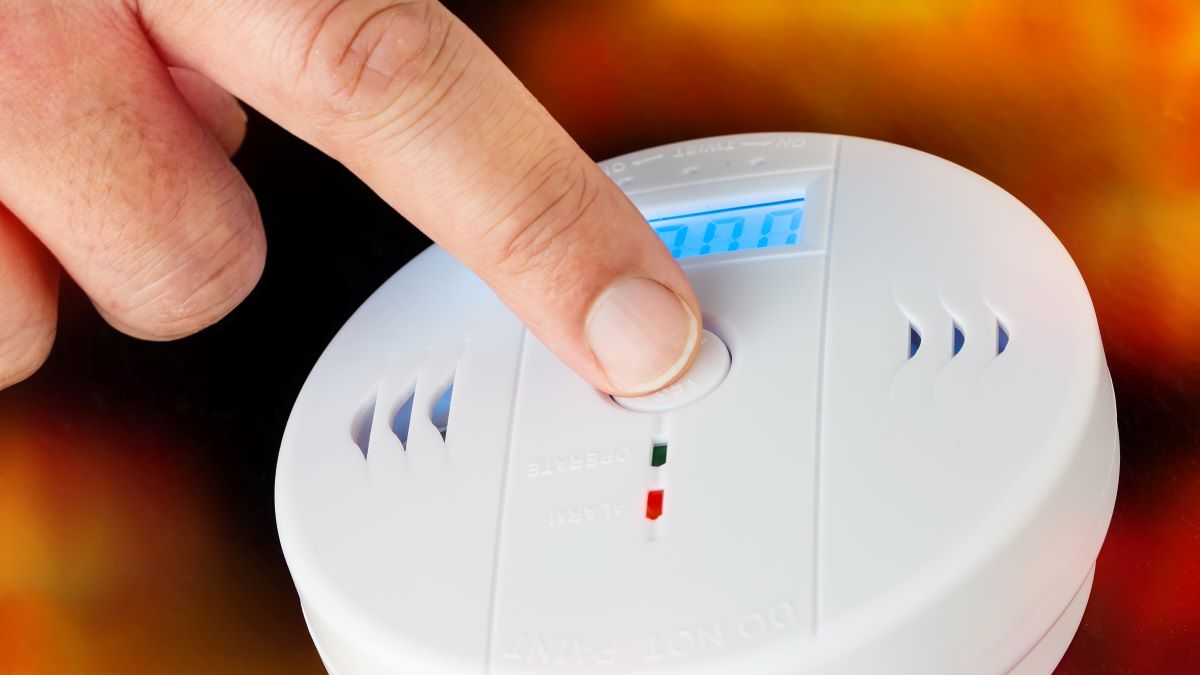 Close-up of man's hand testing a smoke and carbon dioxide detector