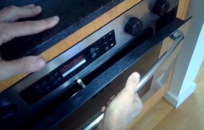 pushing oven door closed on dishtowels