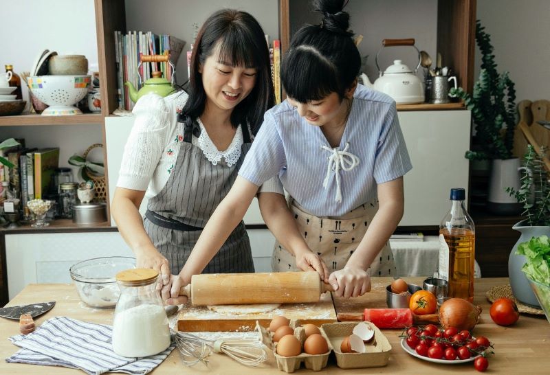 Woman teaching friend how to prepare a dish