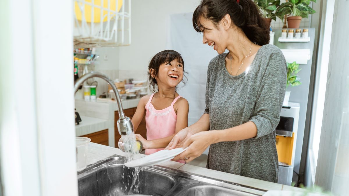 Mother and daughter washing dishes together