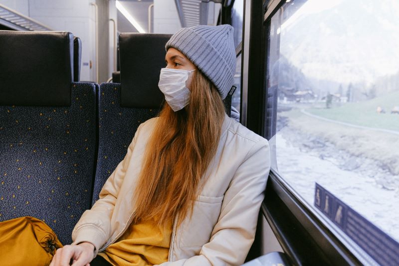 woman on train wearing mask, COVID