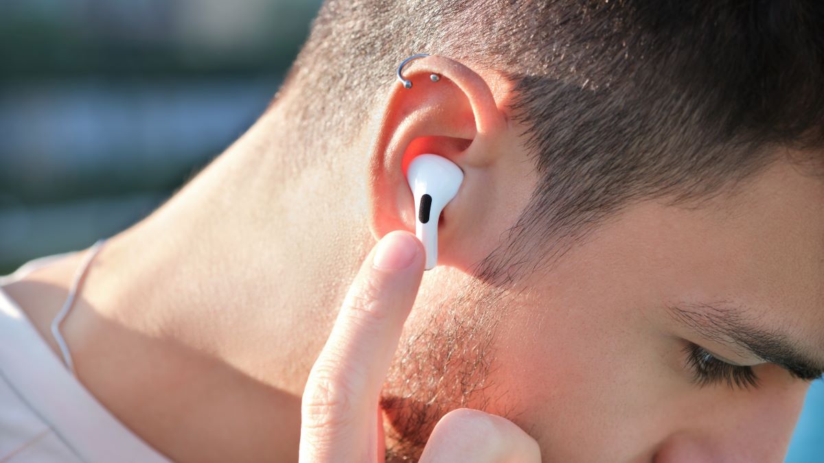Man touching earbud in his ear