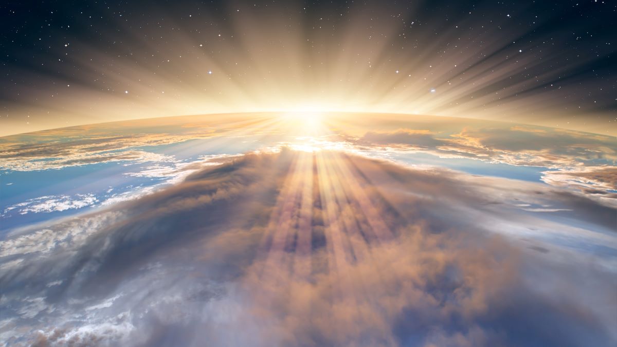 sun peeking over edge of planet earth