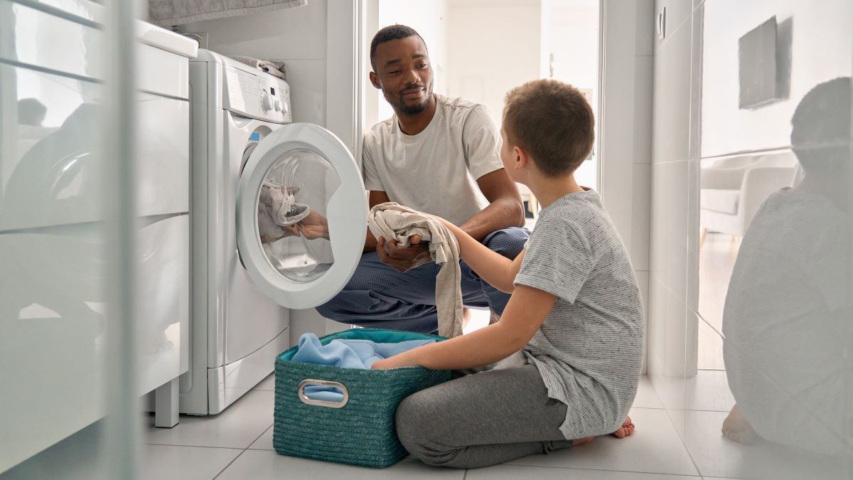 Father and son loading the washing machine